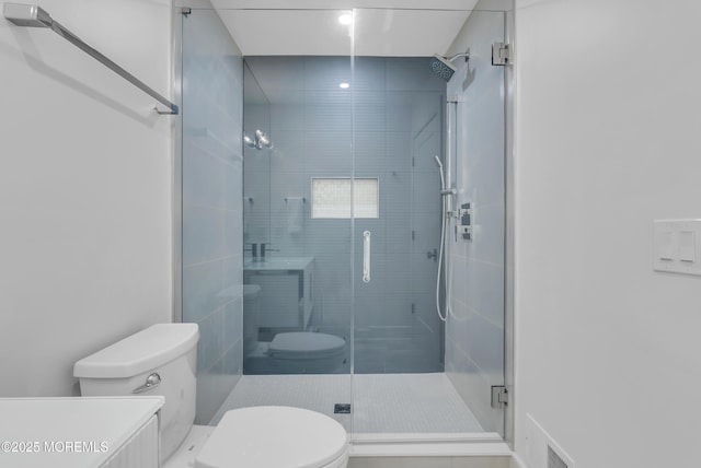 bathroom featuring a shower with door, vanity, and toilet