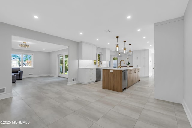 kitchen with dishwasher, decorative light fixtures, white cabinets, and a spacious island