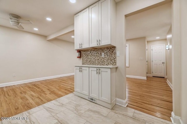 kitchen featuring white cabinetry, ceiling fan, and tasteful backsplash