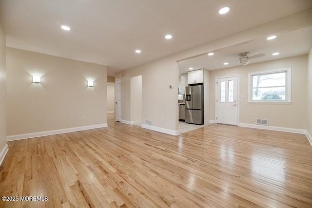 unfurnished living room with ceiling fan and light wood-type flooring