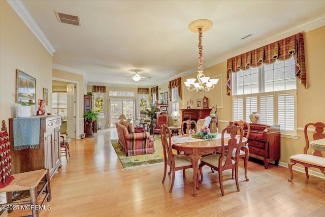 dining space with ornamental molding, a wealth of natural light, and light wood-type flooring