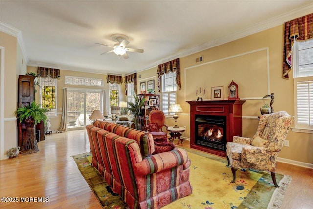 living room featuring ornamental molding, light hardwood / wood-style floors, and a healthy amount of sunlight