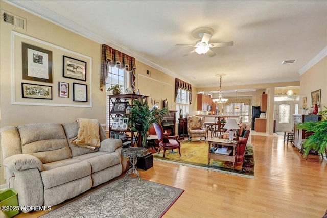 living room featuring crown molding, ceiling fan with notable chandelier, and hardwood / wood-style floors