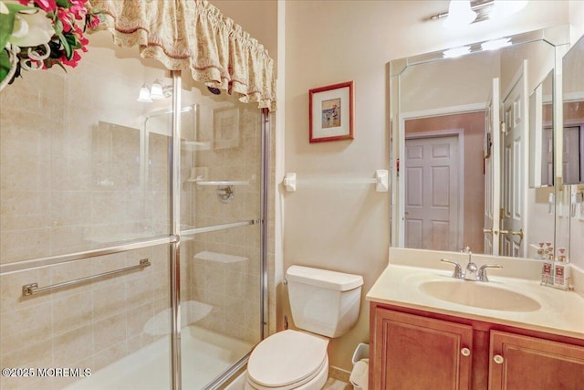 bathroom with walk in shower, vanity, and toilet