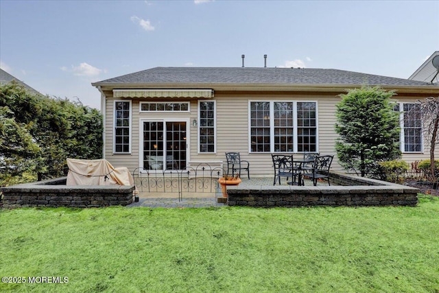 back of property with a yard and a patio area