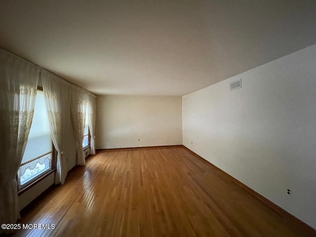 empty room with hardwood / wood-style flooring