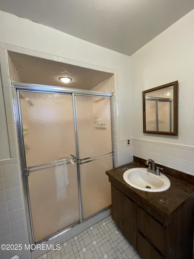 bathroom featuring sink, decorative backsplash, and a shower with door