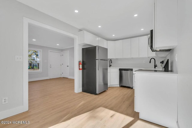 100 Governors Rd Unit 1000, Lakewood, NJ 08701 - kitchen featuring white cabinetry, sink, backsplash, stainless steel appliances, and light hardwood / wood-style flooring