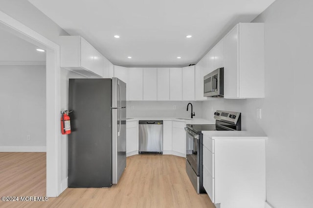 100 Governors Rd Unit 1000, Lakewood, NJ 08701 - kitchen featuring appliances with stainless steel finishes, sink, white cabinets, and light hardwood / wood-style floors