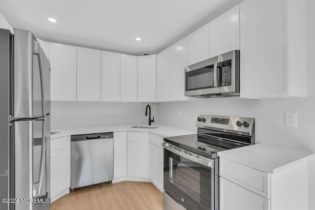 100 Governors Rd Unit 1000, Lakewood, NJ 08701 - kitchen with white cabinetry, appliances with stainless steel finishes, sink, and light hardwood / wood-style floors