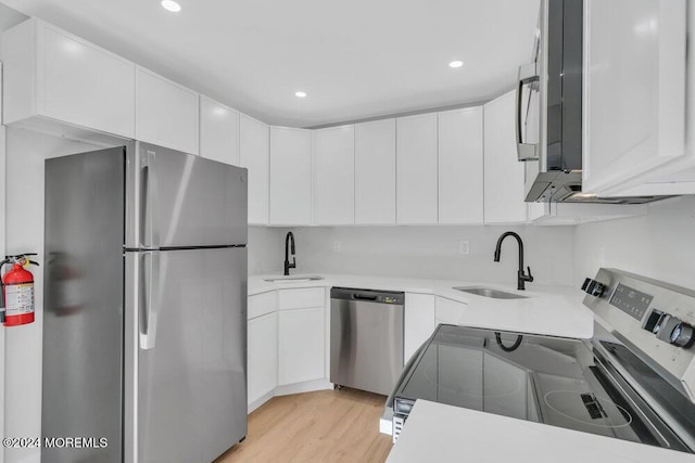 100 Governors Rd Unit 1000, Lakewood, NJ 08701 - kitchen featuring white cabinetry, appliances with stainless steel finishes, sink, and light hardwood / wood-style floors