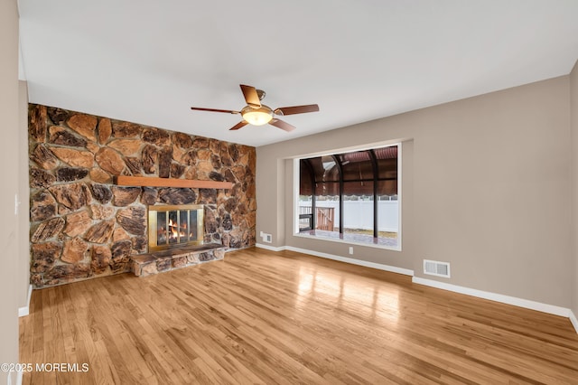 unfurnished living room featuring ceiling fan, a fireplace, and light hardwood / wood-style flooring