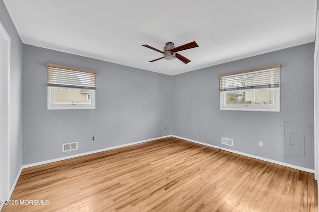 empty room featuring ceiling fan, plenty of natural light, and light wood-type flooring