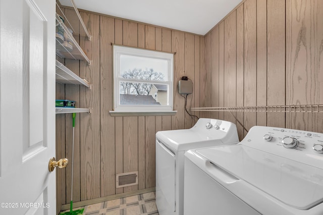 washroom with separate washer and dryer and wood walls