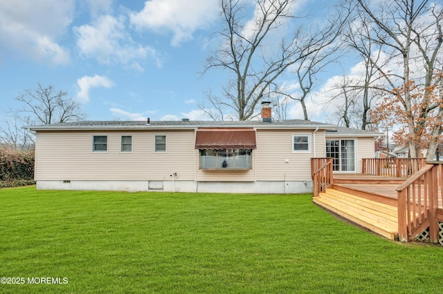 rear view of property with a wooden deck and a lawn