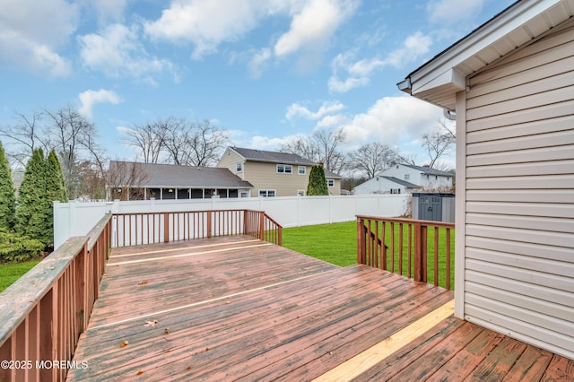 wooden deck featuring a yard and a storage unit