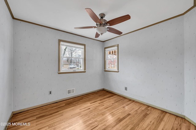 empty room featuring crown molding, light hardwood / wood-style flooring, and ceiling fan