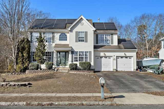 view of front of house with a garage and solar panels