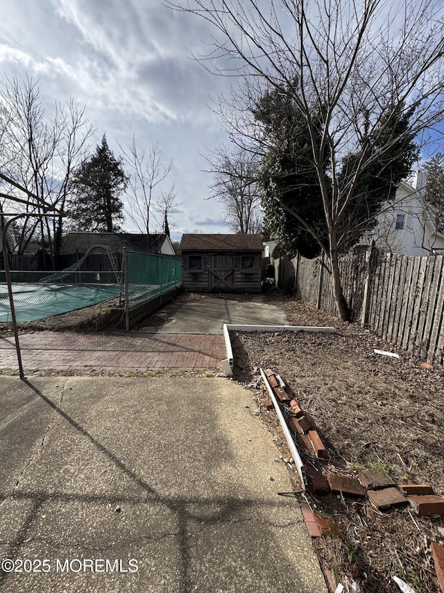 exterior space with a pool, an outbuilding, and a patio area