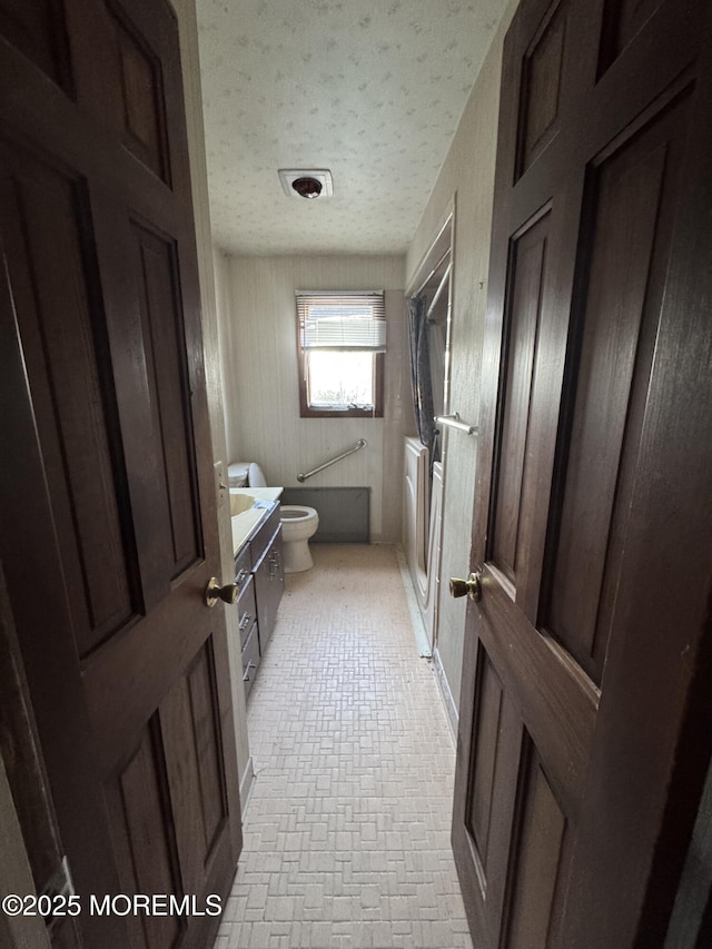 full bathroom featuring vanity, toilet, separate shower and tub, and a textured ceiling