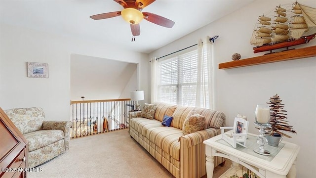 carpeted living area with a ceiling fan