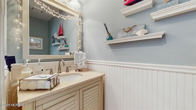 bathroom with vanity, visible vents, and wainscoting