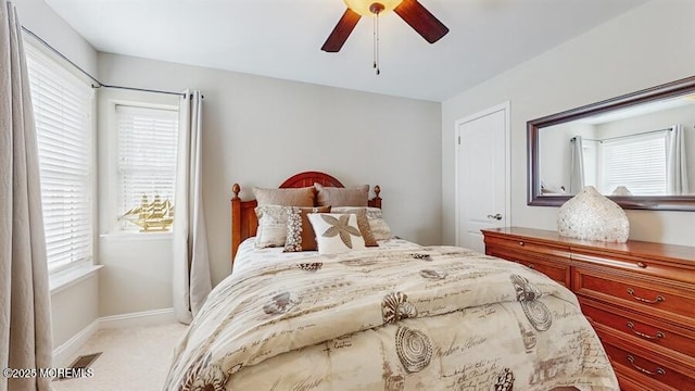 carpeted bedroom featuring ceiling fan, visible vents, and baseboards