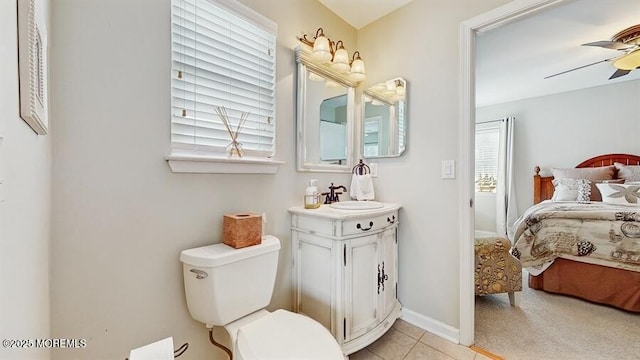 bathroom with tile patterned flooring, toilet, a ceiling fan, baseboards, and ensuite bath