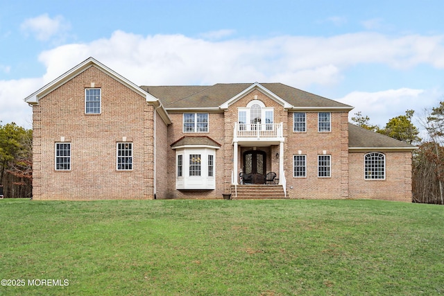 view of front of house featuring a balcony and a front yard