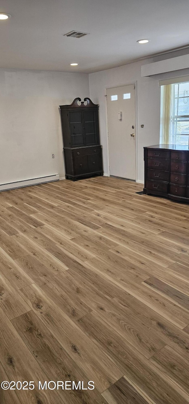 entryway with wood-type flooring and baseboard heating