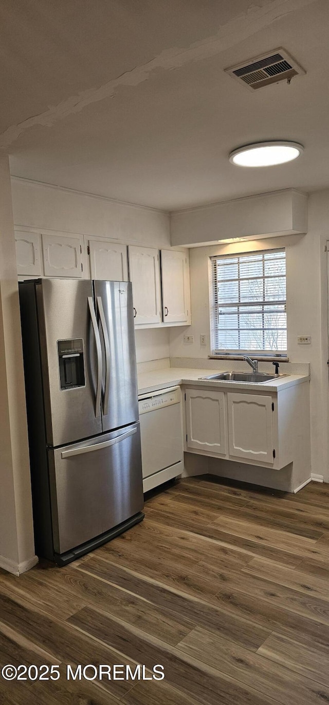 kitchen with white cabinetry, sink, dark hardwood / wood-style flooring, white dishwasher, and stainless steel refrigerator with ice dispenser