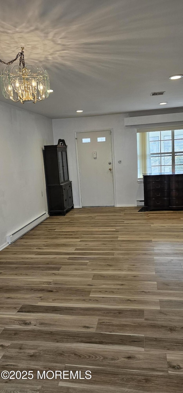 unfurnished living room featuring a baseboard radiator and dark hardwood / wood-style floors