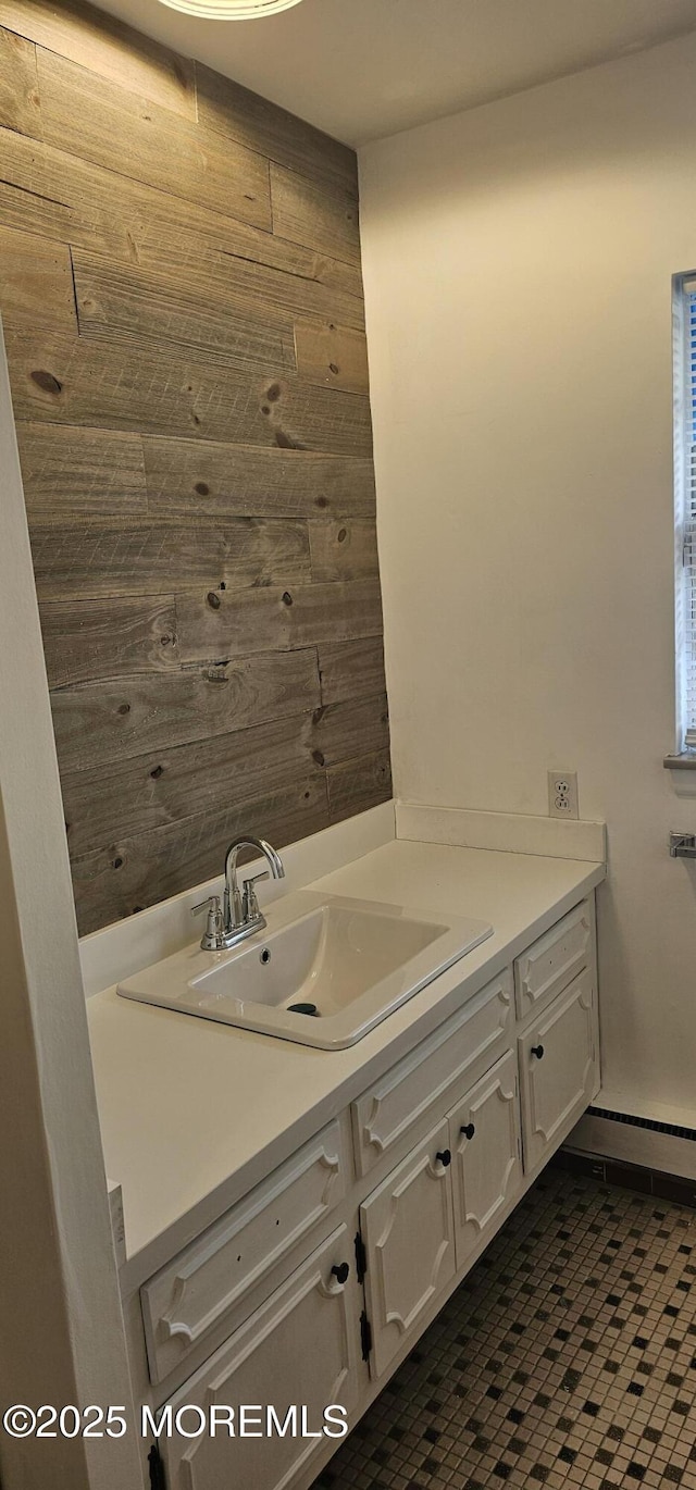 bathroom with vanity, wooden walls, and a baseboard radiator