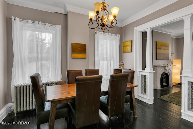 dining room featuring ornate columns, radiator heating unit, ornamental molding, dark wood-type flooring, and an inviting chandelier