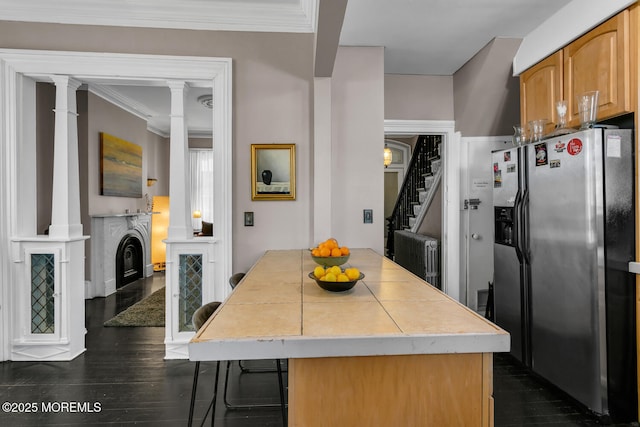 kitchen featuring dark hardwood / wood-style flooring, stainless steel fridge with ice dispenser, ornamental molding, and ornate columns