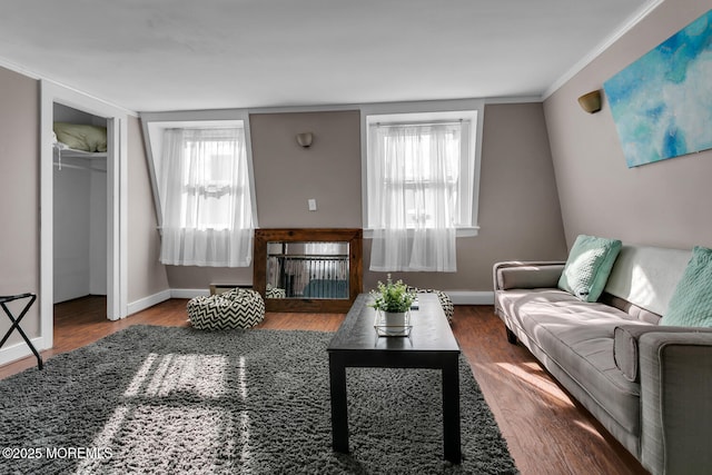 living room with ornamental molding, a healthy amount of sunlight, a fireplace, and wood-type flooring