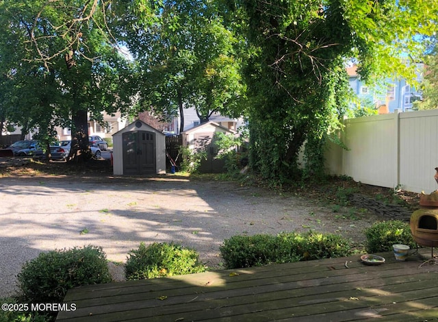 view of yard featuring a wooden deck and a shed