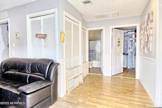 living area featuring light hardwood / wood-style flooring and a textured ceiling