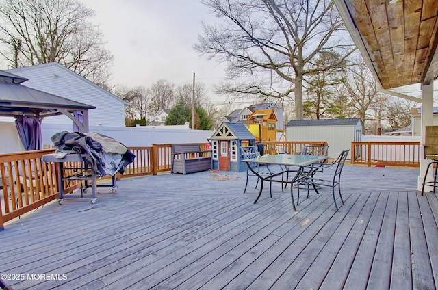 wooden terrace featuring a shed and a gazebo