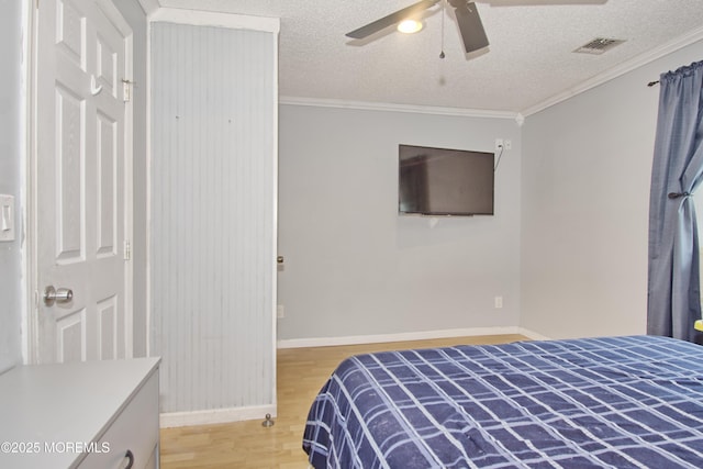 bedroom with a textured ceiling, crown molding, ceiling fan, and light hardwood / wood-style flooring