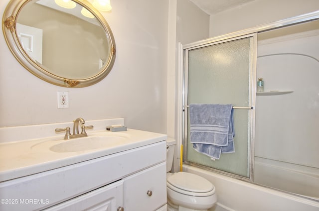 full bathroom with enclosed tub / shower combo, vanity, and toilet