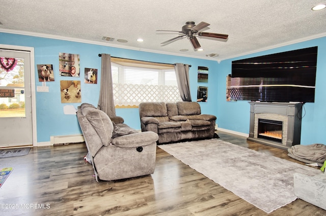 living room featuring a baseboard radiator, a textured ceiling, ceiling fan, dark hardwood / wood-style flooring, and ornamental molding