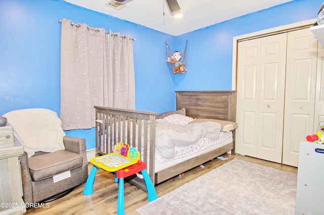 bedroom featuring light wood-type flooring, a closet, and ceiling fan