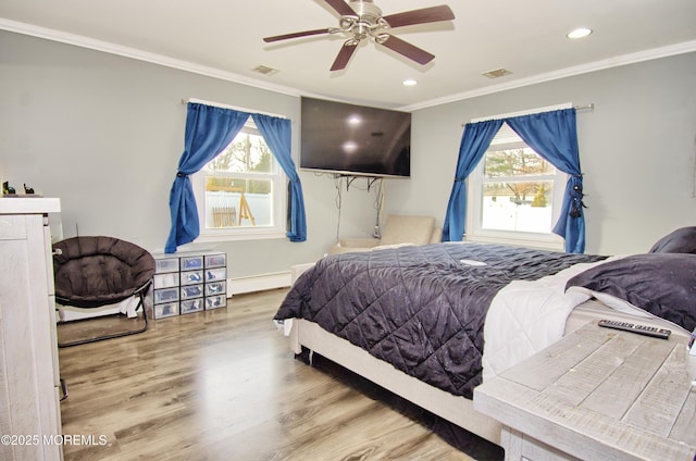 bedroom with multiple windows, hardwood / wood-style flooring, crown molding, and a baseboard radiator