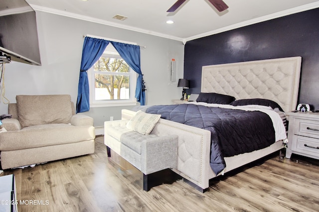 bedroom with a baseboard heating unit, crown molding, ceiling fan, and wood-type flooring