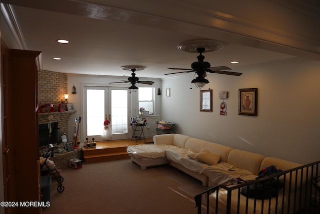 carpeted living room with ceiling fan, ornamental molding, and a brick fireplace