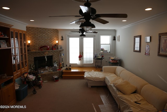 carpeted living room featuring crown molding, a brick fireplace, ceiling fan, and french doors