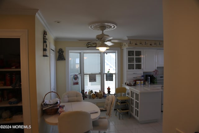 dining room with crown molding, ceiling fan, and light tile patterned floors