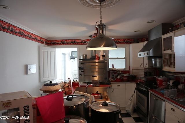 kitchen featuring wall chimney range hood, stainless steel appliances, and white cabinets