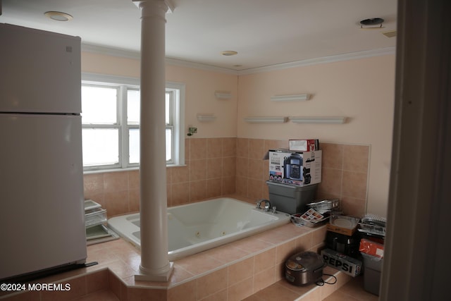 bathroom with tiled tub, ornamental molding, and decorative columns